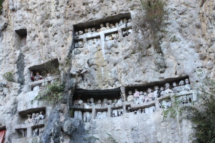 Tumba excavada en la roca con representaciones en madera de los hombres allí enterrados